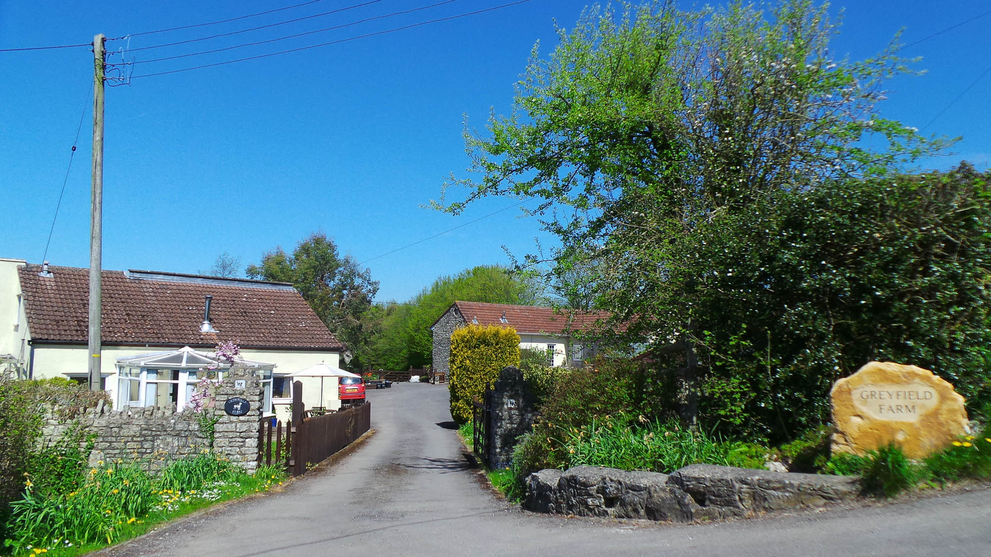 The driveway into Greyfield Farm Cottages, the signs say Greyfield Farm