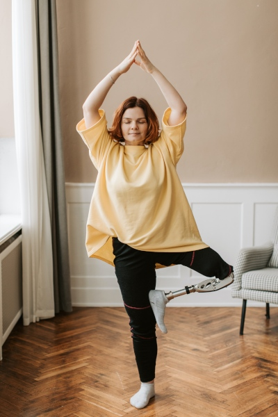 Woman standing in yoga pose with artificial leg.